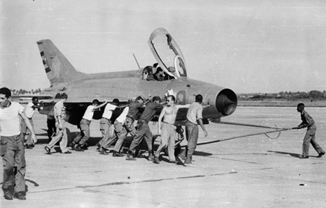 A ground crew muscles a MiG-21 after a mission.